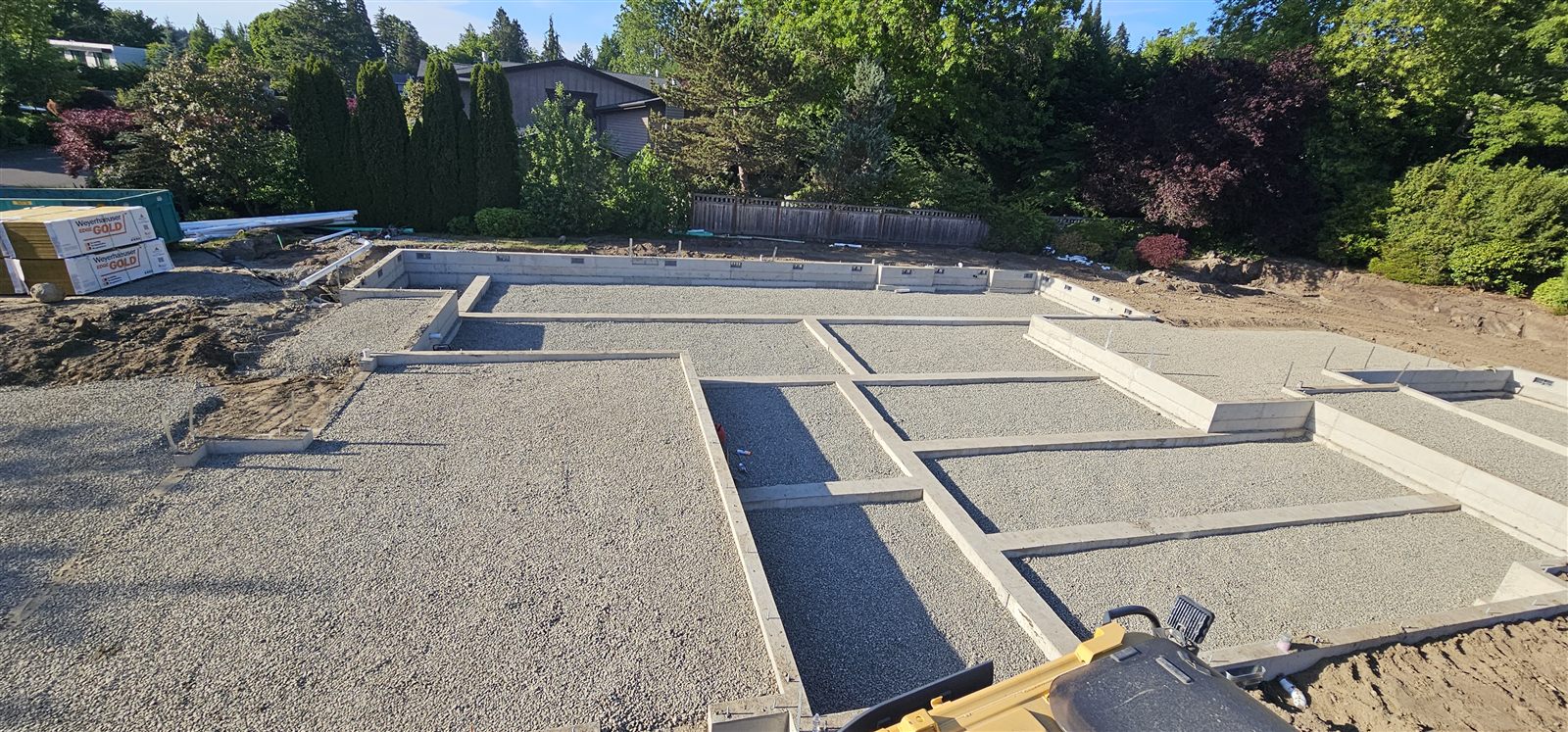Compacted gravel pad with foundation footings formed